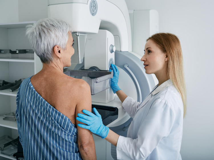 Doctor helping patient during a mammogram screening