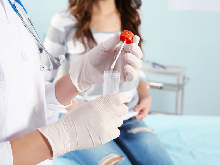 Doctor labelling a urine sample container for testing